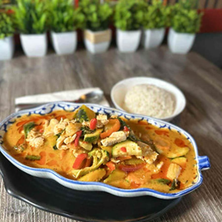 Thai curry with herbs in a patterned dish