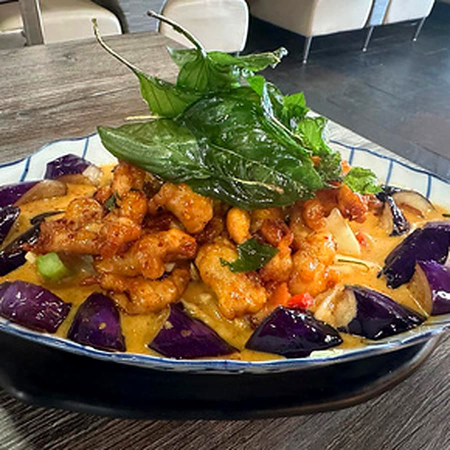 Wide noodle dish with shrimp and fresh vegetables